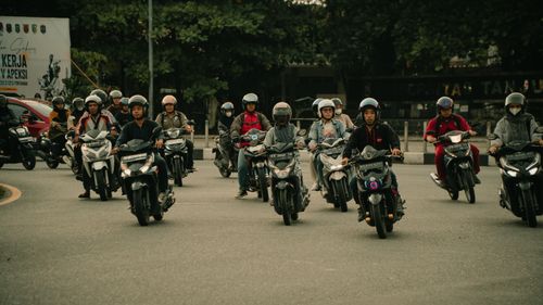 Free Motorcyclists wearing helmets navigate a bustling urban street. Stock Photo