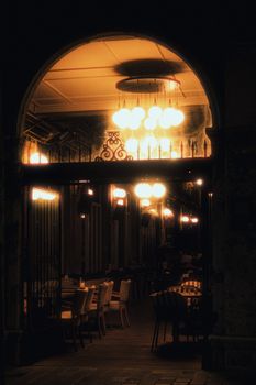 A dimly lit entrance to a café at night, showcasing warm and inviting lighting.
