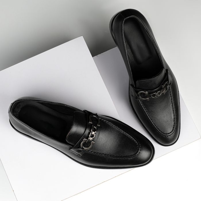 Black leather bit loafers on white blocks — photo by Danyal Malik on Pexels