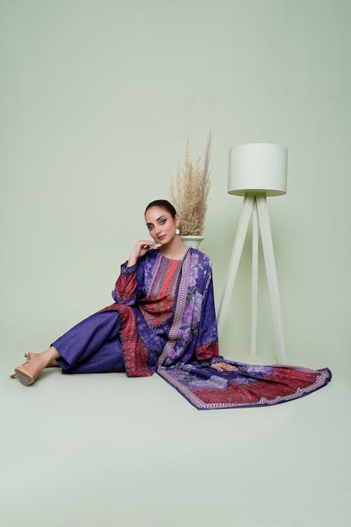 Young Woman Wearing Traditional Clothing Sitting on the Floor and Posing 