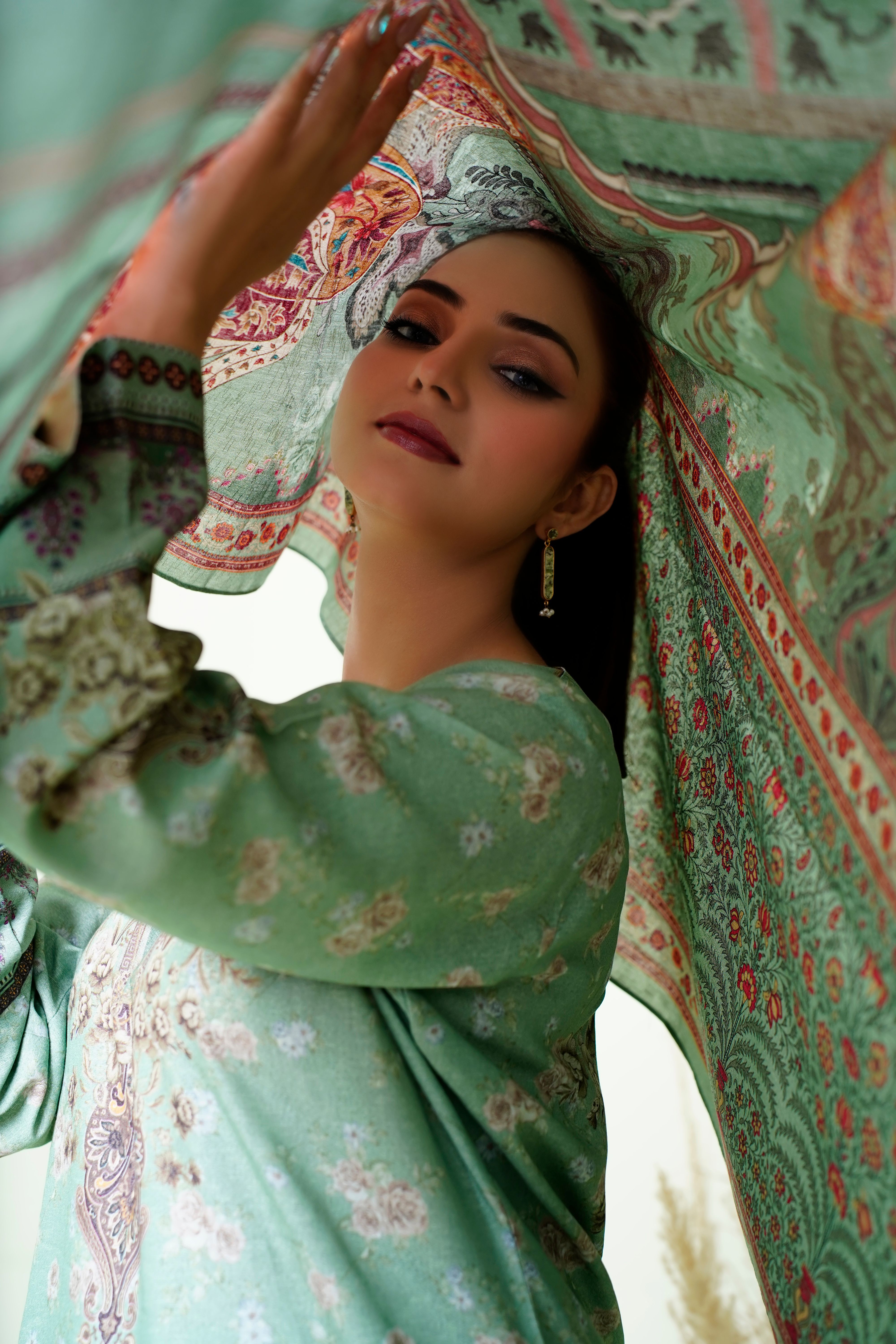 Portrait of a woman posing elegantly in traditional clothing with colorful drapery.
