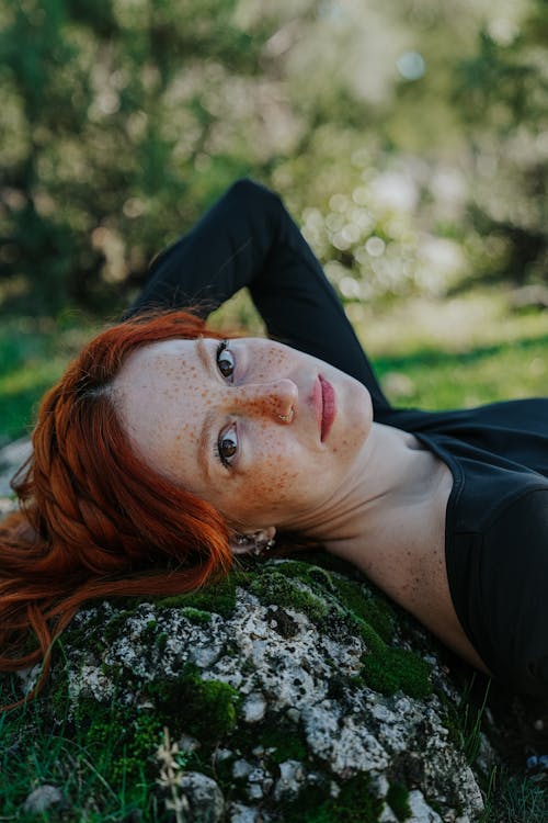 Young Redhead Lying on the Ground in a Park in Summer 