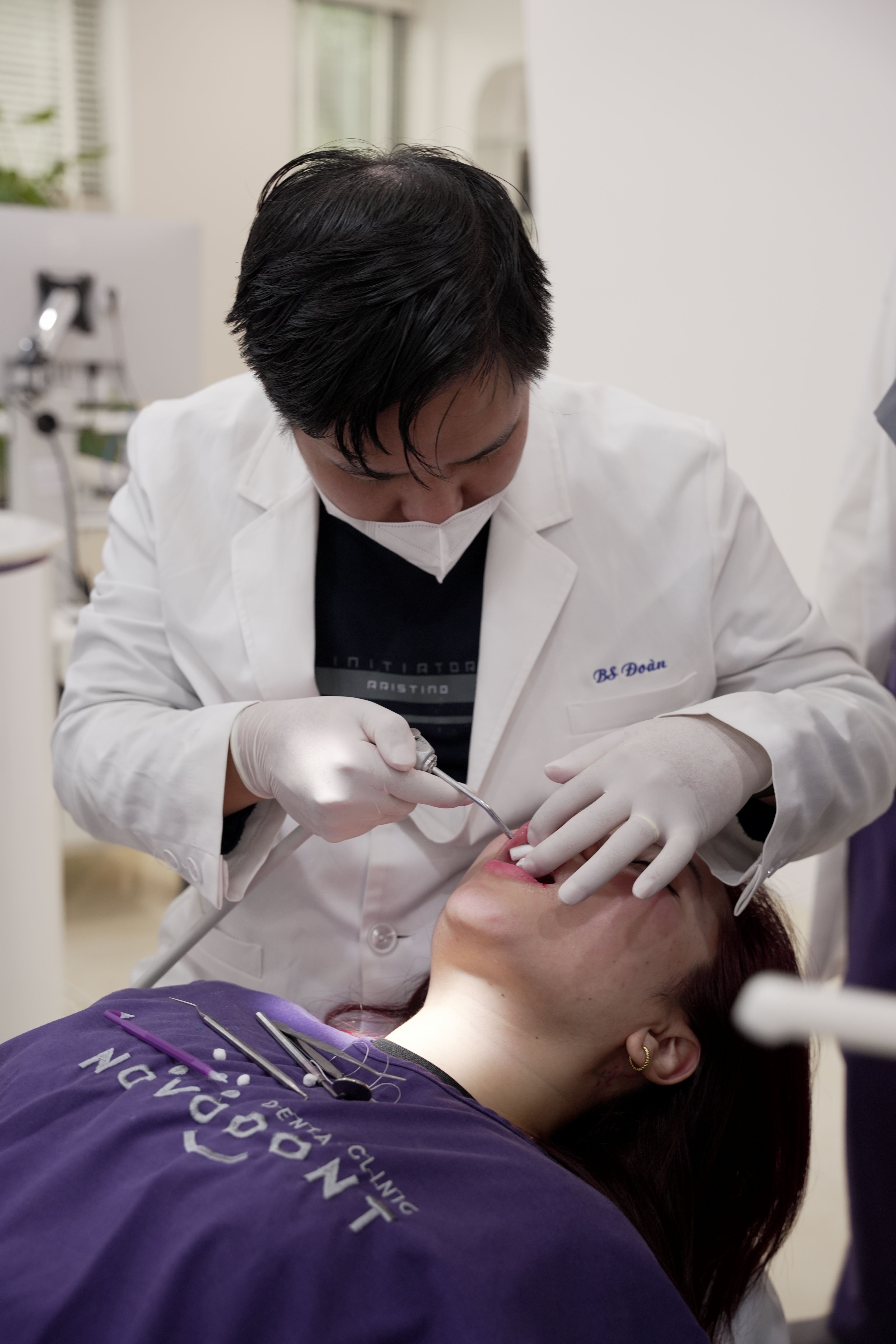 Dentist treating a patient during an oral examination in a clinic setting.