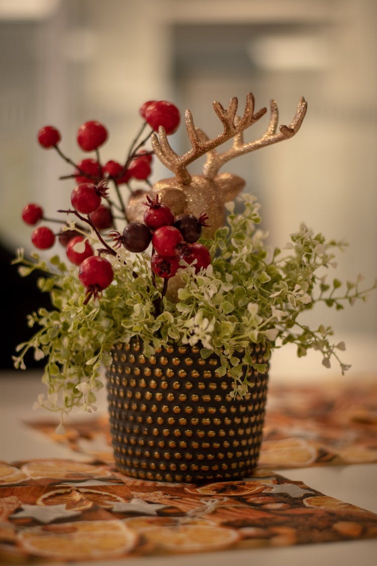 A Plant And Christmas Ornament On The Table 