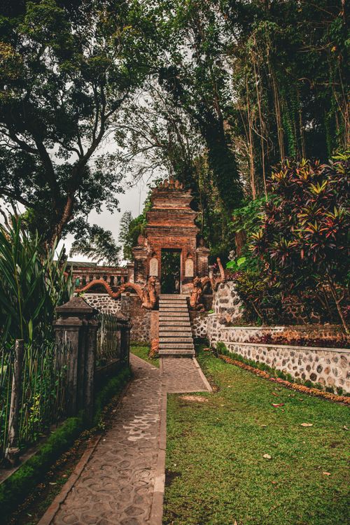 Free Discover the serene beauty of an ancient temple gate nestled in Bali's lush jungle, Indonesia. Stock Photo