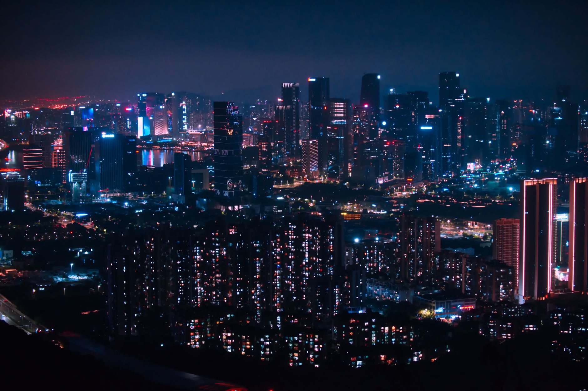 Stunning cityscape of Shenzhen at night with glowing skyscrapers and bustling urban life.