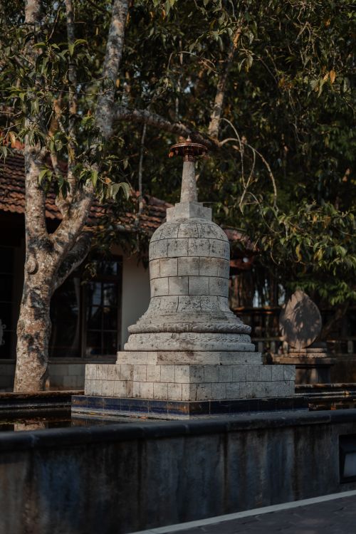 Free A serene stone monument surrounded by trees in a tranquil park setting. Stock Photo