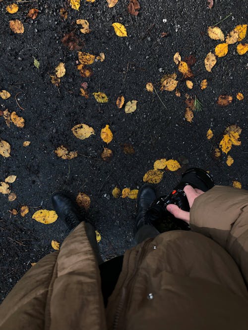 Man Standing and Holding Camera in Autumn 