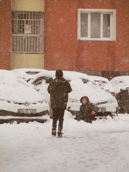 Kids Playing in the Snow in a City 