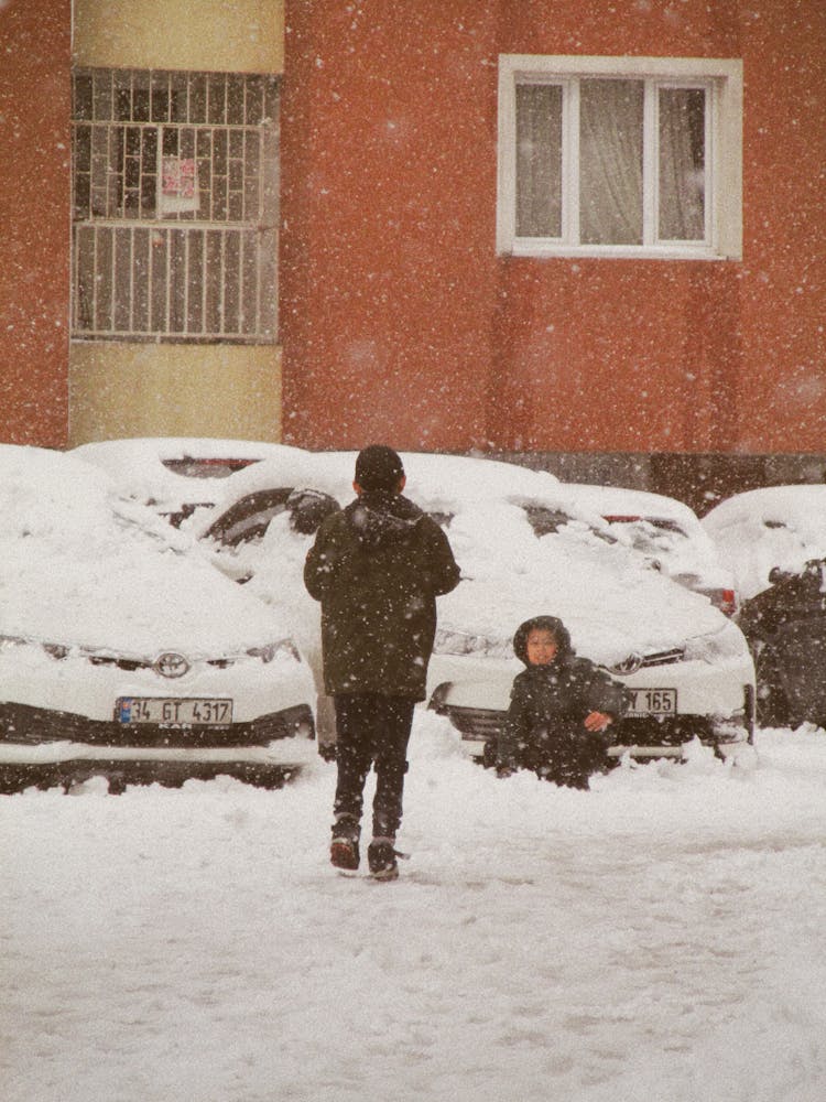 Kids Playing In The Snow In A City 