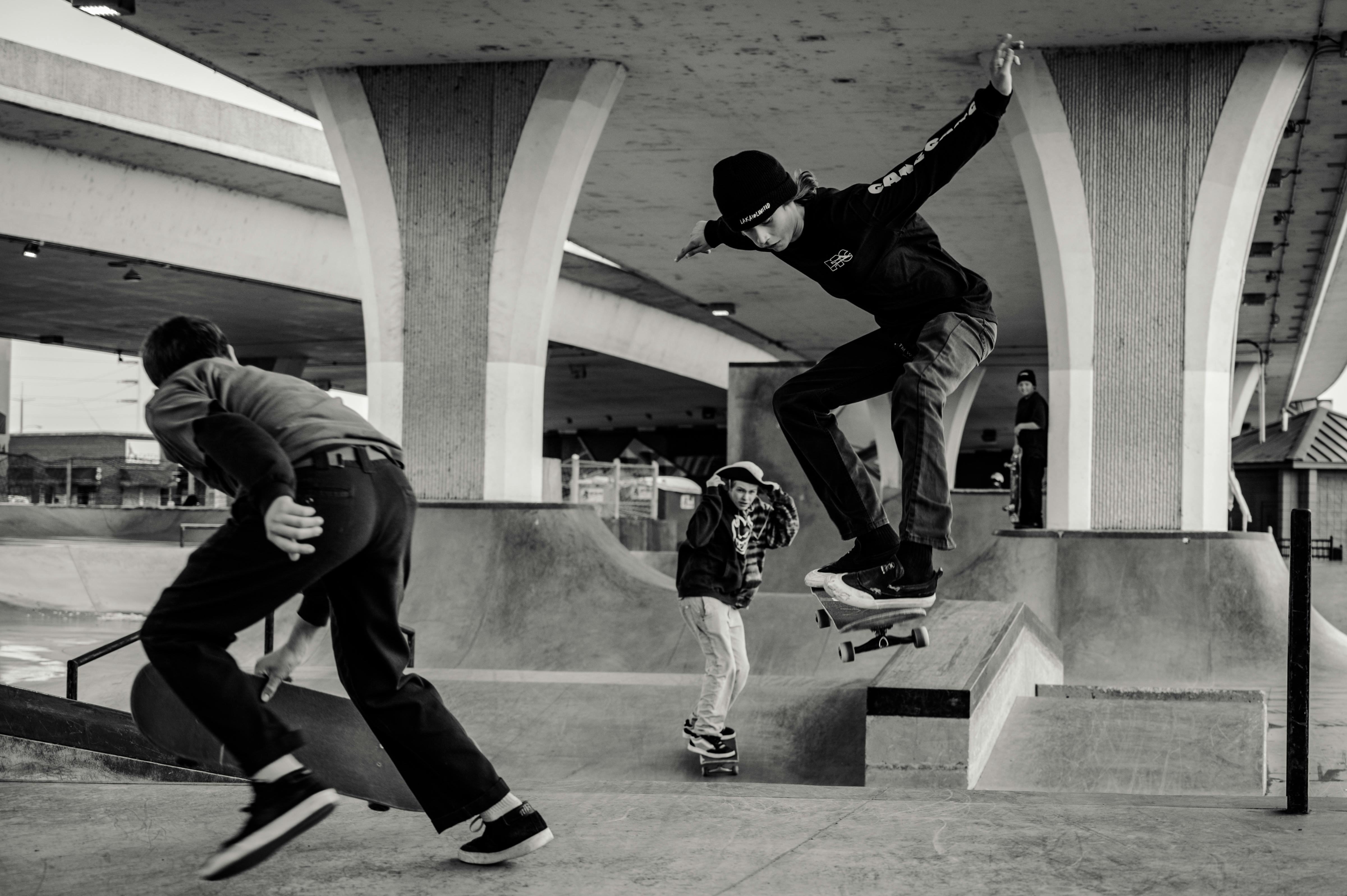 monochrome photo of men skateboarding