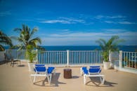 在配有躺椅和棕榈树的海滨阳台上欣赏宁静的海景