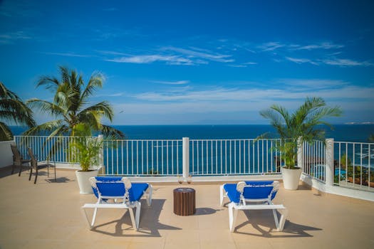 在海滨阳台上，躺在躺椅间，伴着棕榈树，欣赏宁静的海景