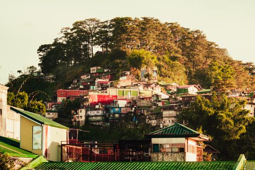 A vibrant hillside town with colorful rooftops under bright summer sunlight.