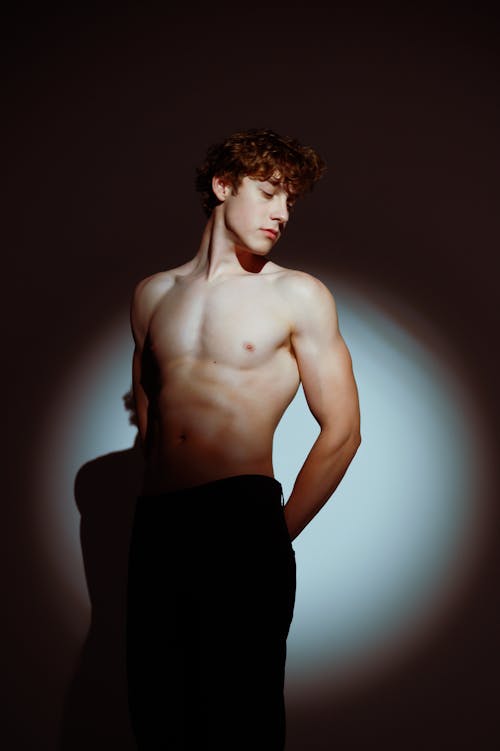 Studio Shoot of a Young Shirtless Man in Spotlight