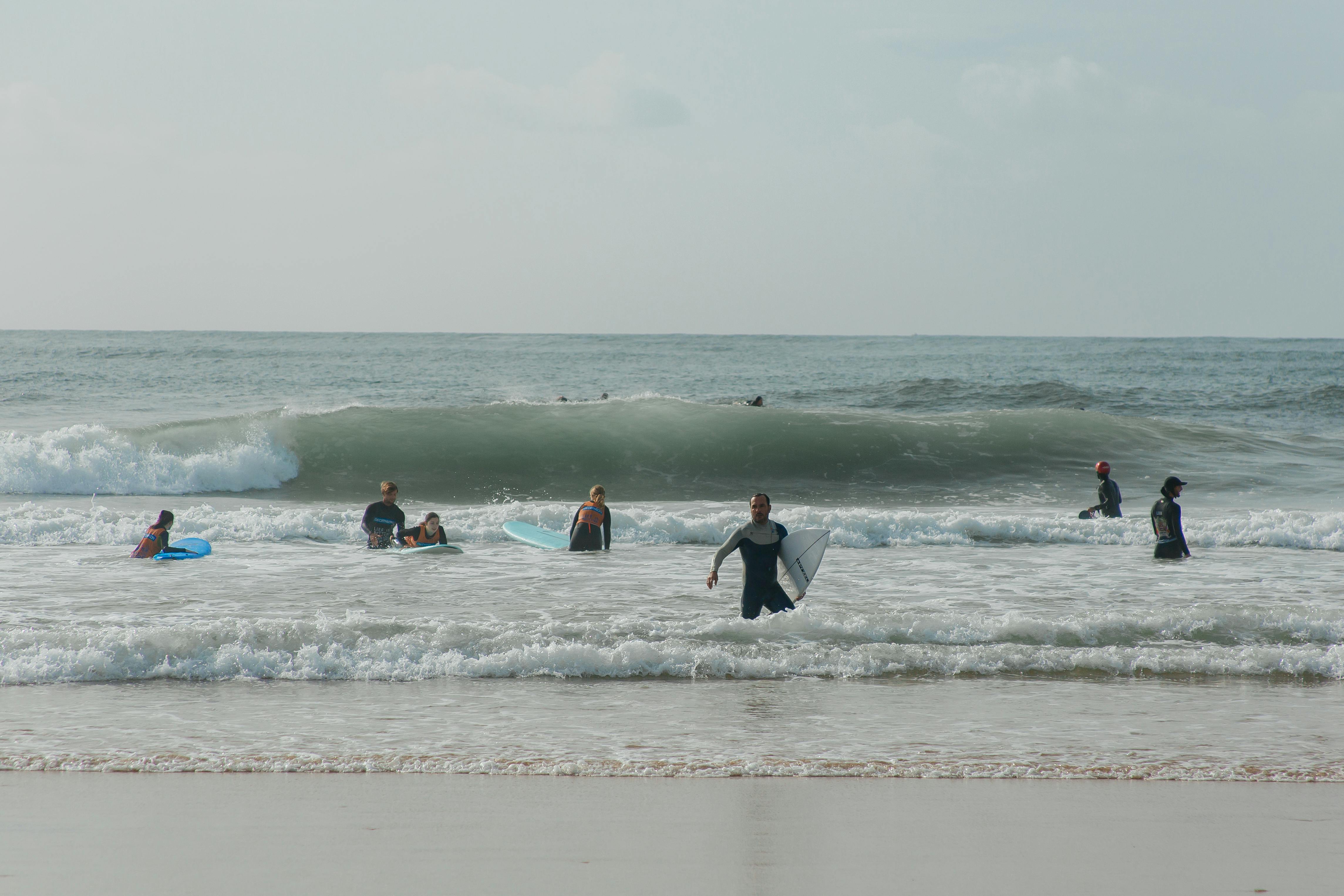 Group of surfers enjoying a day of surfing and fun at the beach with waves.