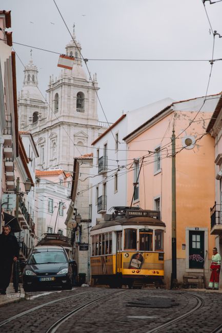 Lisbon's iconic Tram 28 passing through the historic streets near São Vicente de Fora in Portugal.