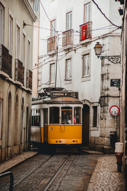 Charming vintage tram navigating the narrow streets of Lisbon's historic old town.