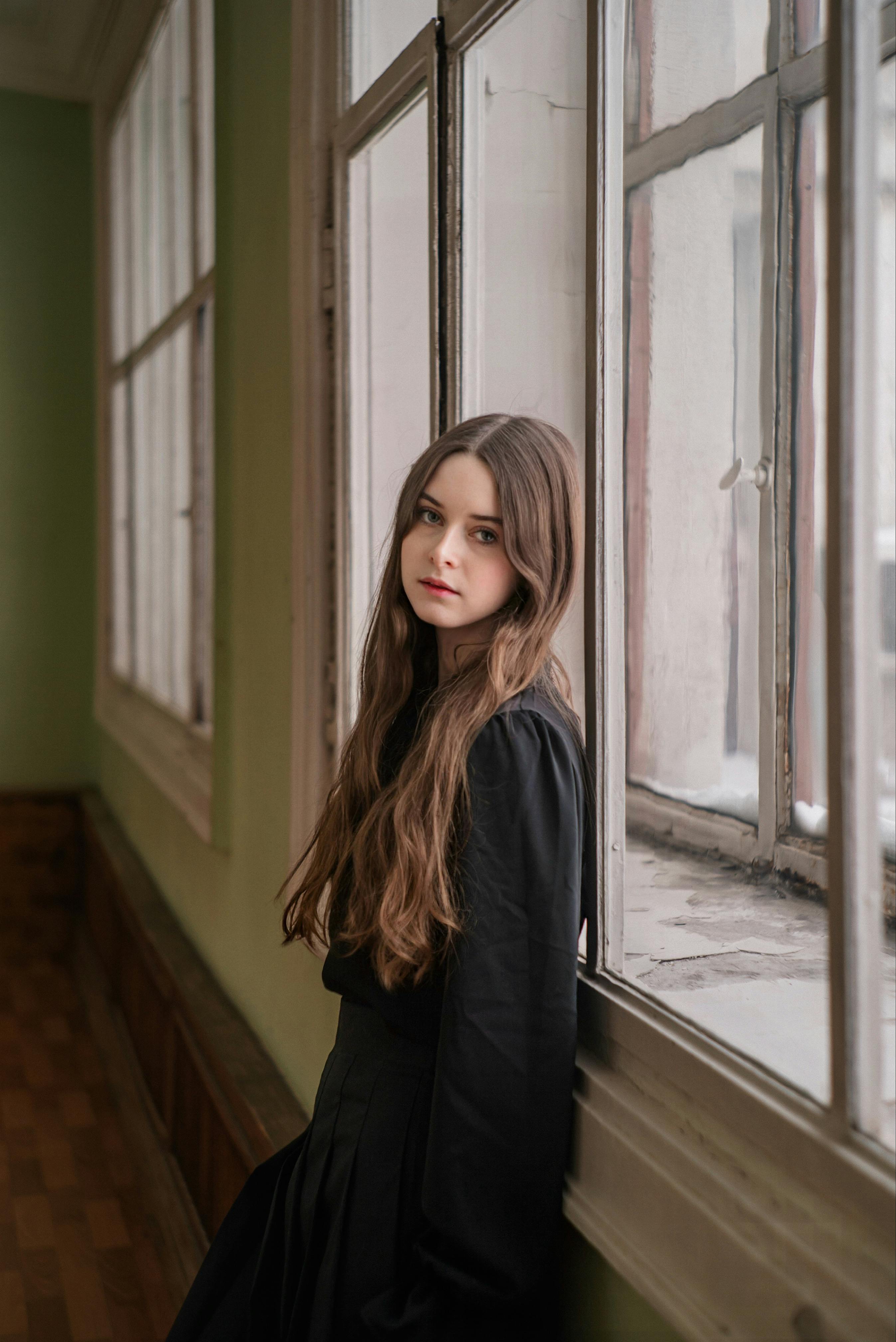 Kostenlos Nachdenkliche Frau Stützte Sich Auf Fensterbank Flur  Stock-Foto