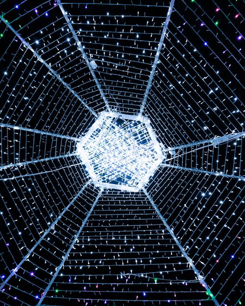 Free A mesmerizing view of an illuminated light tunnel at night, perfect for festive themes. Stock Photo