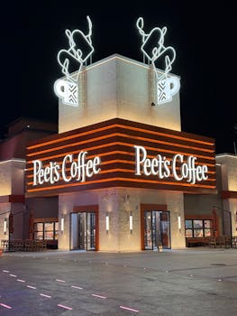 Night view of Peet's Coffee in Tongzhou, Beijing with vibrant neon lights and modern architecture.