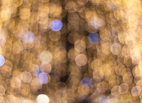 A vibrant and festive abstract background with golden and blue bokeh lights creating a soft, dreamy effect.