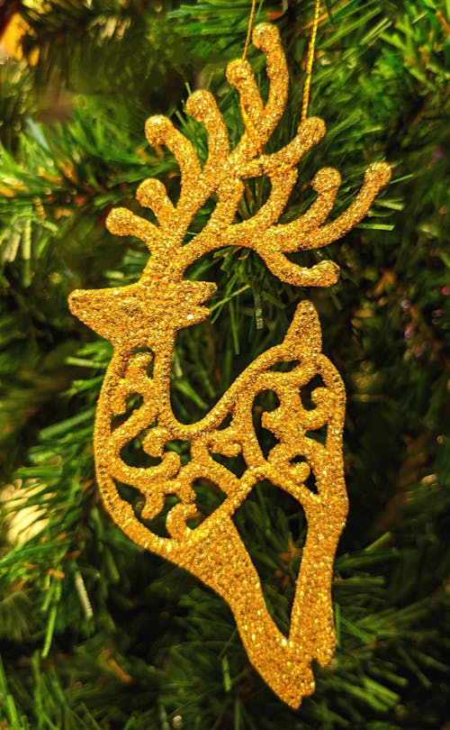 Golden reindeer ornament hanging from a christmas tree
