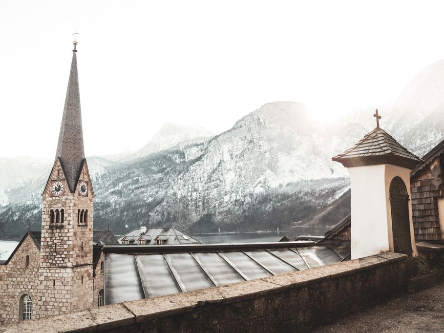 Beautiful church with Gothic architecture amidst snowcapped mountains in Hallstatt, Austria.