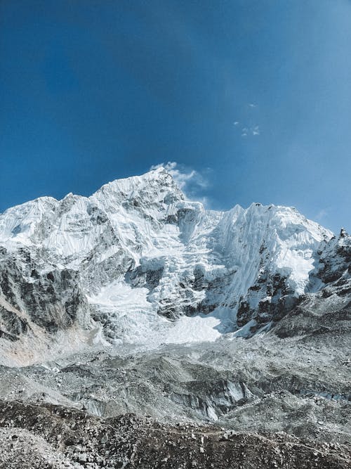 View of Rocky Snowcapped Mountains under Blue Sky 