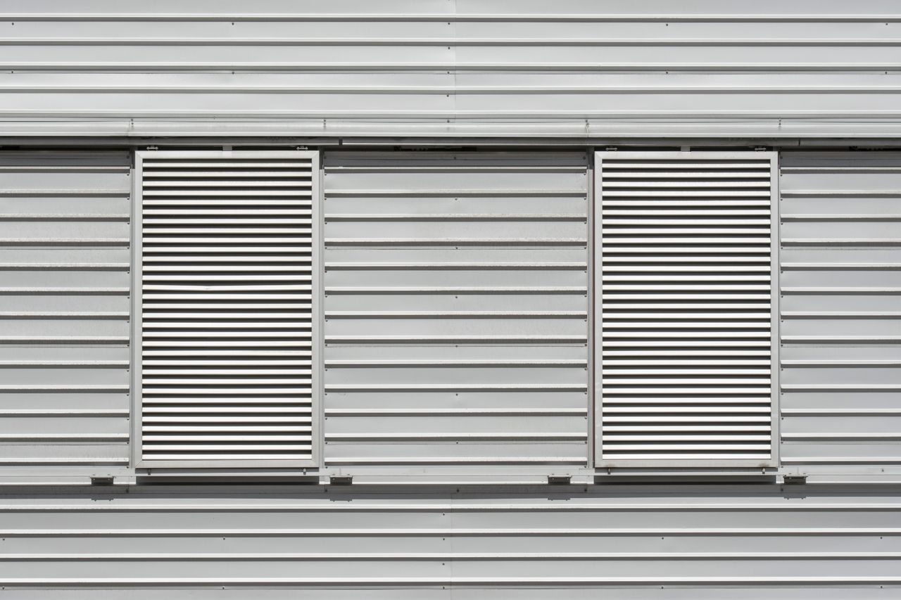close up view of a modern industrial building exterior with louvered w
