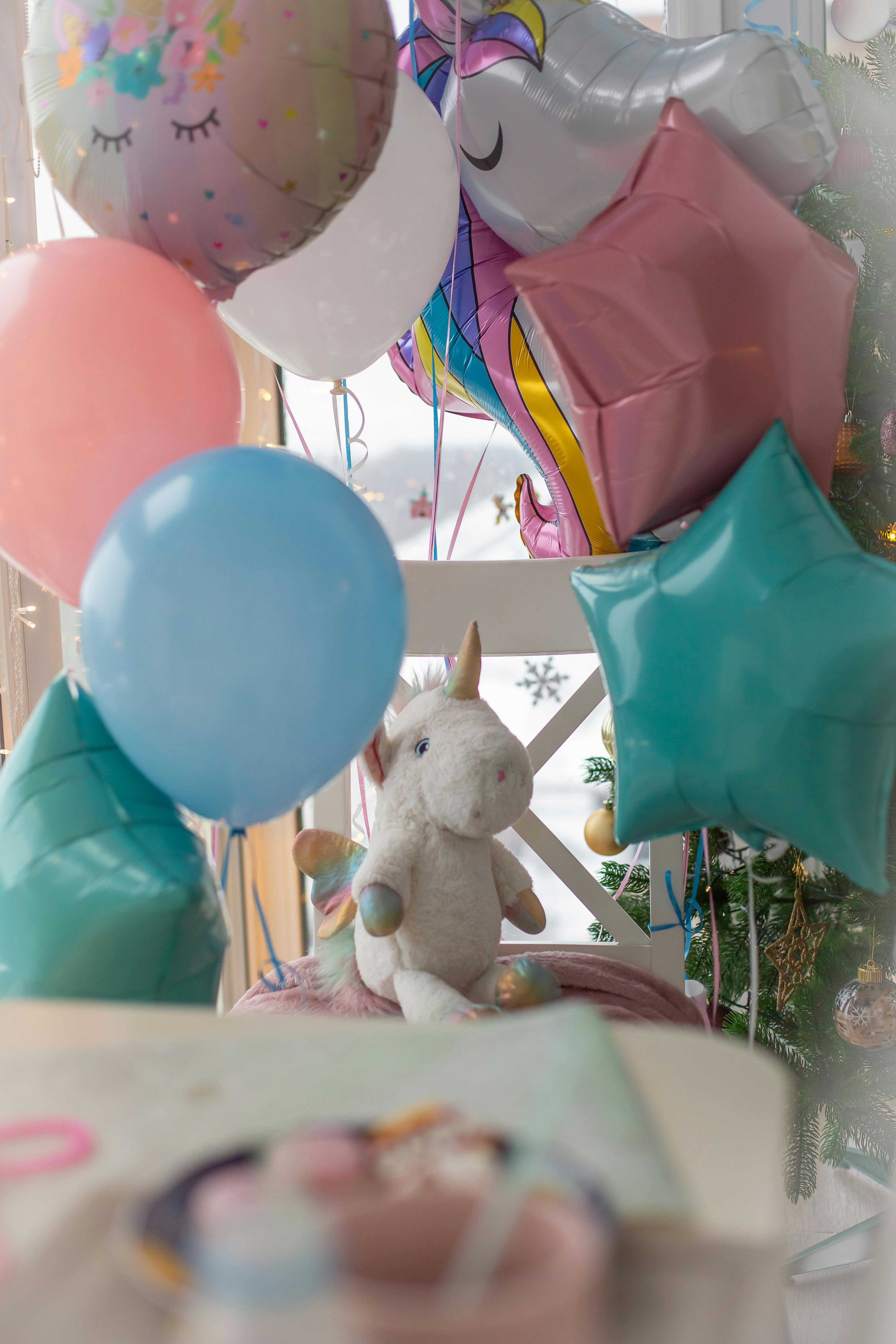 A festive indoor unicorn-themed birthday party setup with colorful balloons.