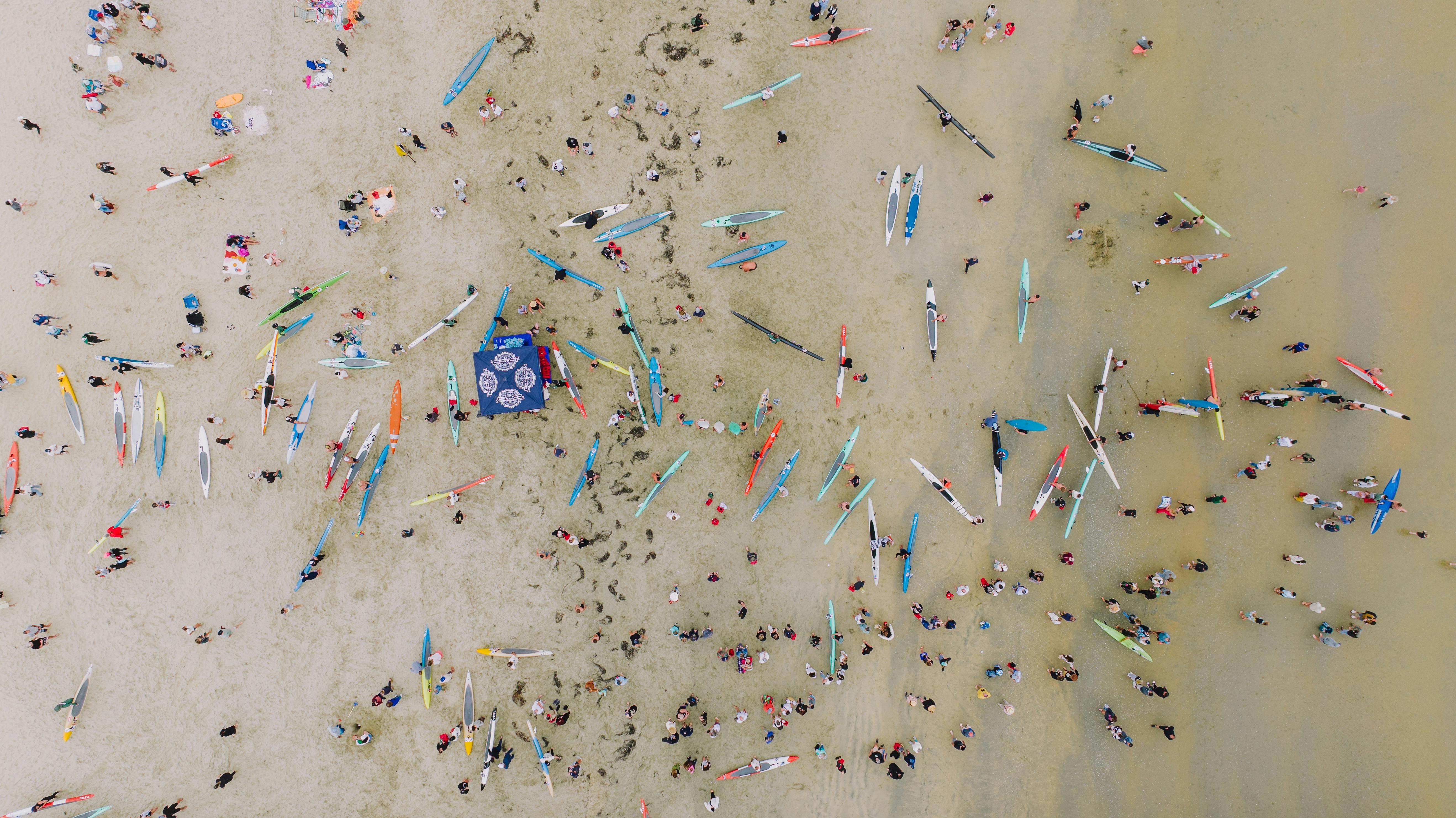 Crowd of Tourists with Paddle Boards on a California Beach