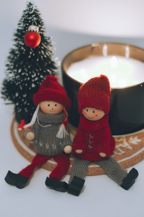 Free Adorable Christmas dolls with candle and tree, bringing holiday cheer. Stock Photo