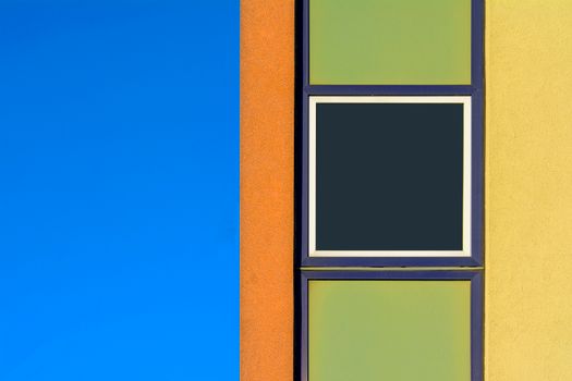 A window with a square in it and a blue and green wall