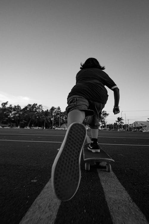 Teenager on Skateboard at Parking Lot