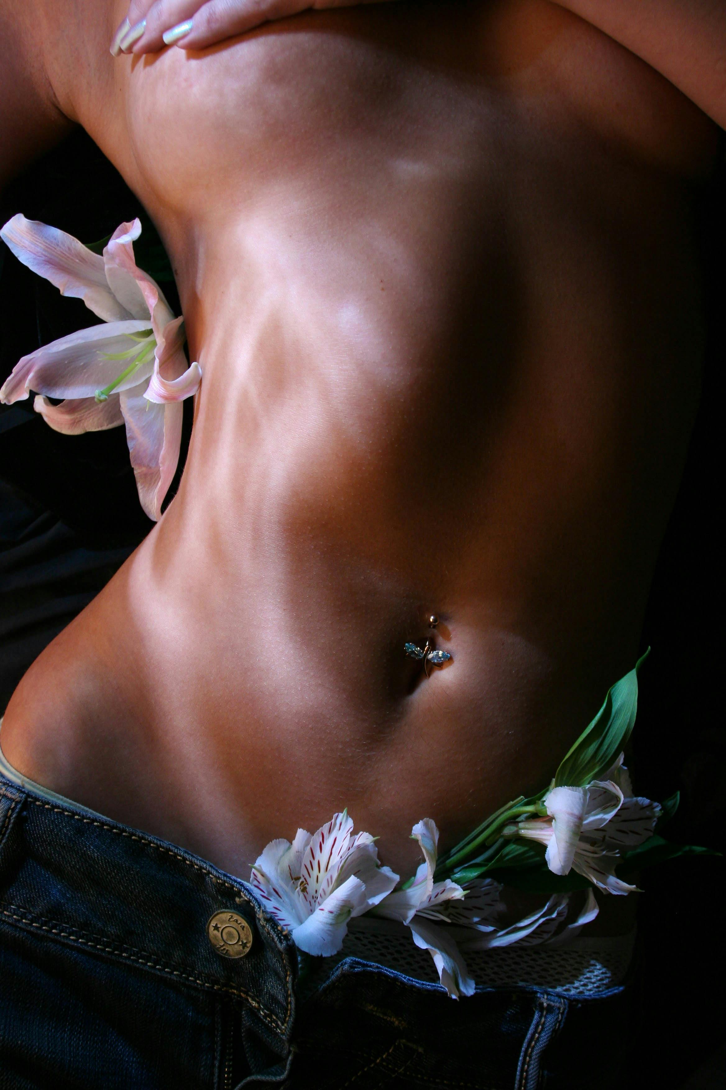 Torso of a Naked Woman with Orchid Flowers · Free Stock Photo