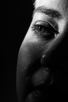 A striking black and white close-up portrait highlighting a woman's eye detail.