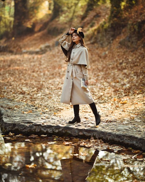 Woman in Coat on Footbridge in Forest in Autumn