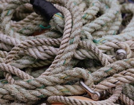 Detailed shot of old, coiled jute ropes intertwined in a nautical environment.