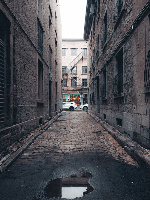 Free Explore the rustic charm of a cobblestone alleyway in Montreal's urban landscape. Stock Photo