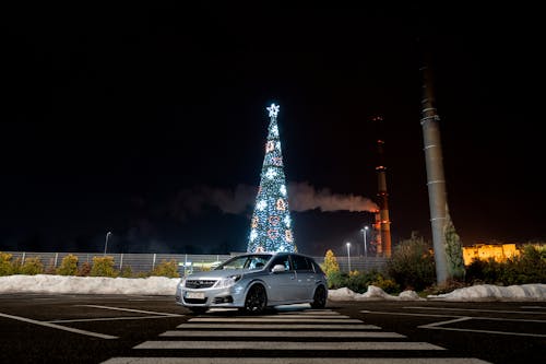 A car parked in front of a christmas tree