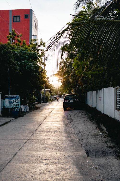 Free Explore an urban street in Moalboal, Philippines, captured beautifully during sunset with lush greenery and city vibes. Stock Photo