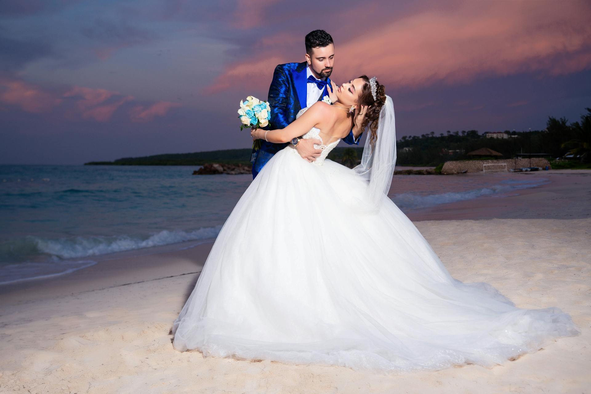 Bride and groom captured in a sunset embrace on Falmouth beach, Jamaica.