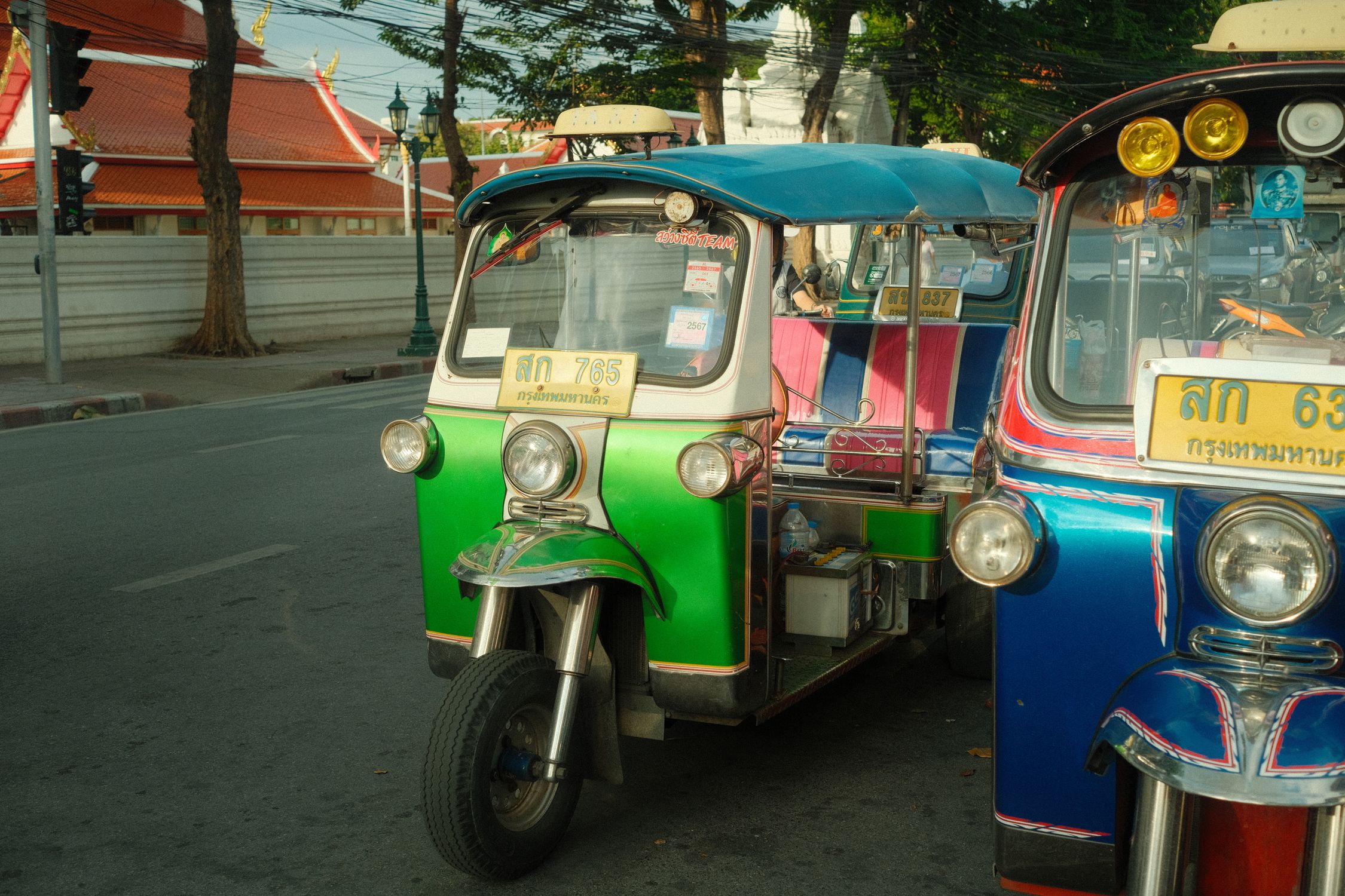 Colorful auto rickshaws line a bustling street in Bangkok, capturing urban transportation