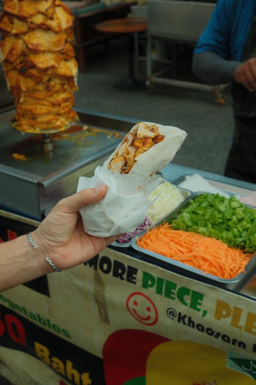 Hand Holding a Kebab in the Street Market 