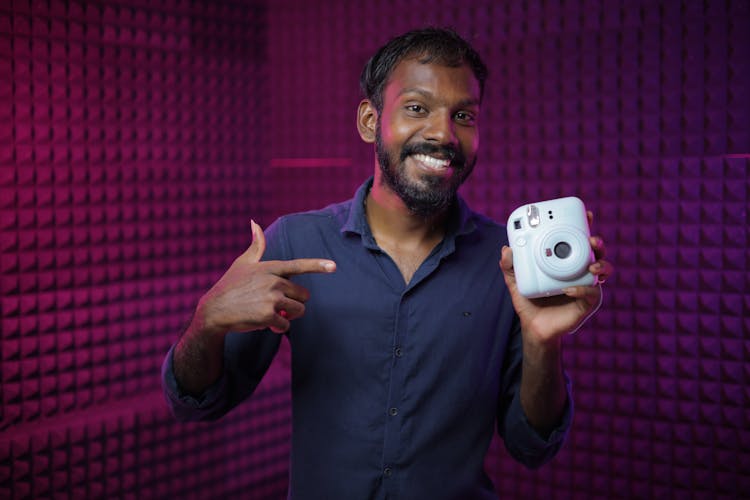 African Man Holding A White Camera 