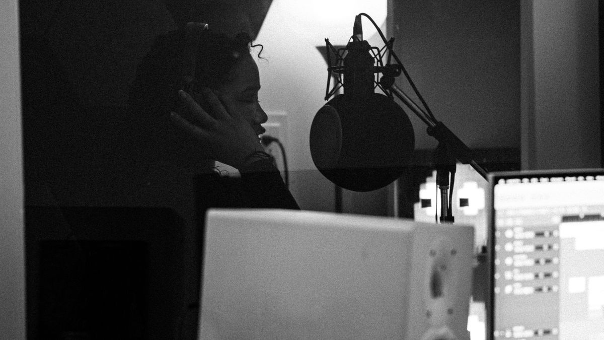 Female artist recording vocals in a professional music studio