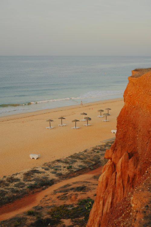 Free Explore the serene beauty of Algarve's coast with sandy shores and striking eroded cliffs at sunset. Stock Photo