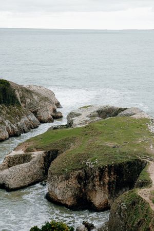 Green coastal cliffs above a sheltered inlet — photo by Tahir Osman on Pexels