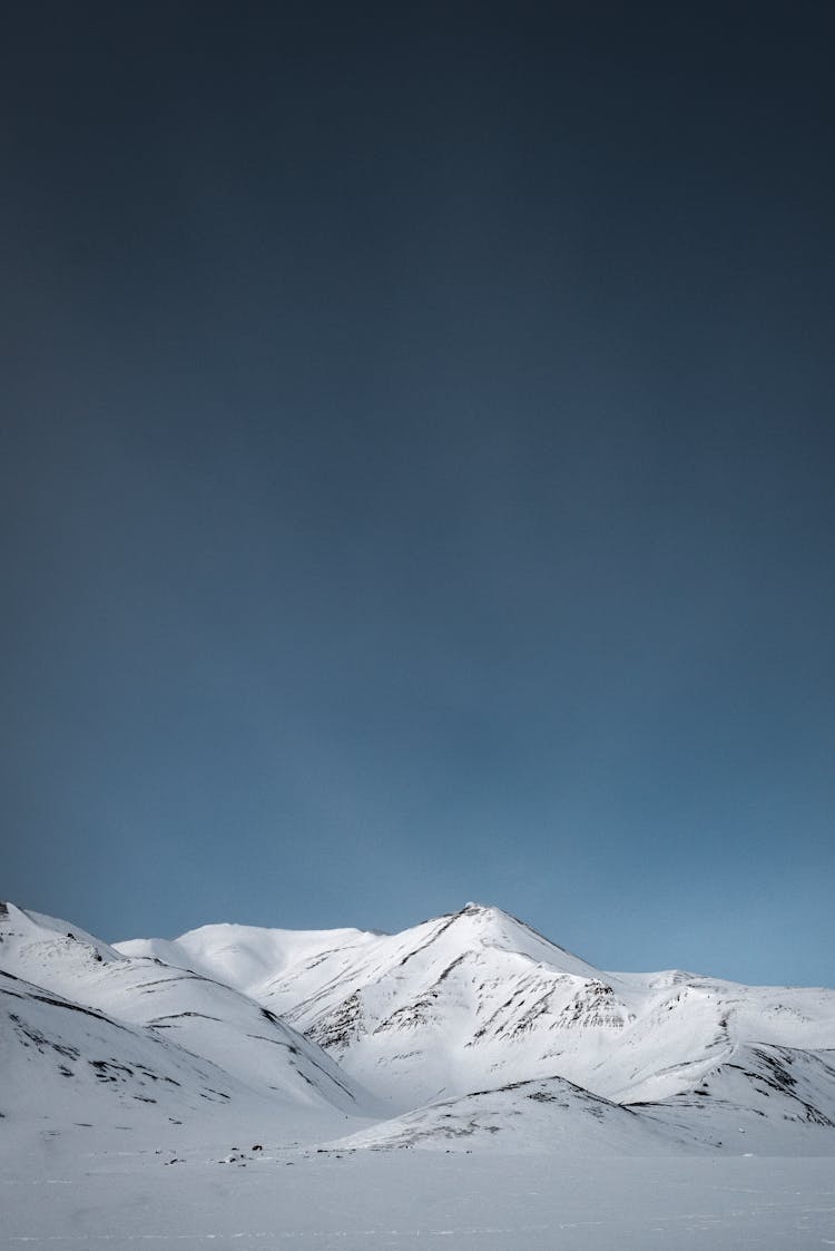 A Snow Covered Mountain With A Blue Sky